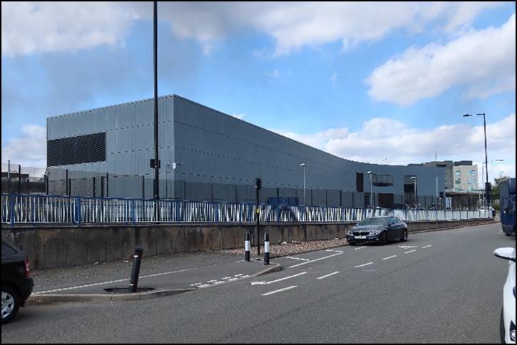 A road with cars and a building in the background

Description automatically generated with low confidence