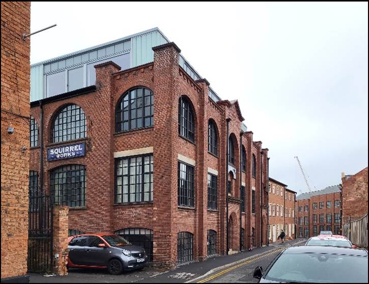 A brick building with cars parked in front of it

Description automatically generated with medium confidence