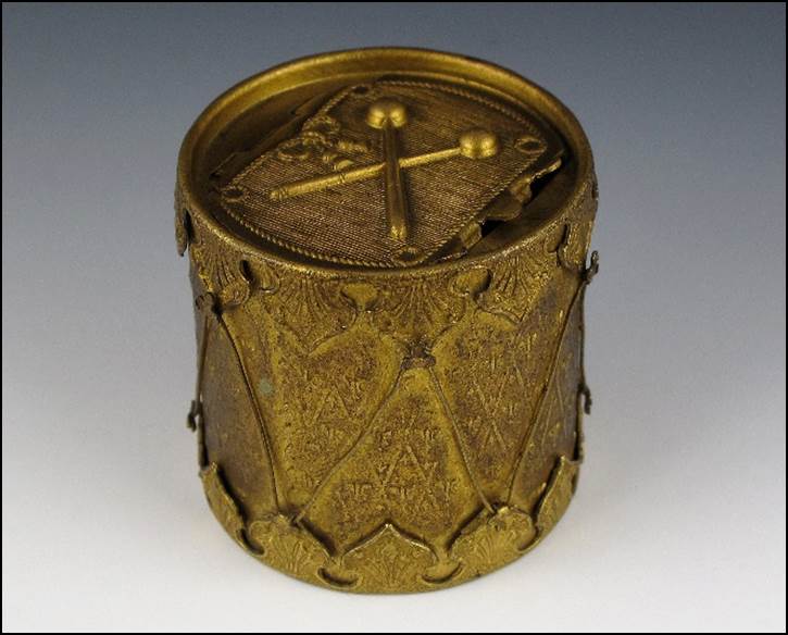 A gold cylinder with a cross on it

Description automatically generated