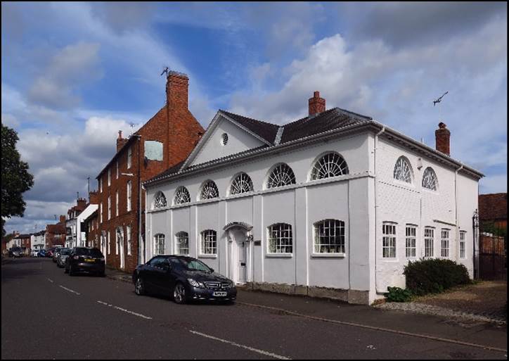 A white building with a black car parked in front of it

Description automatically generated with low confidence