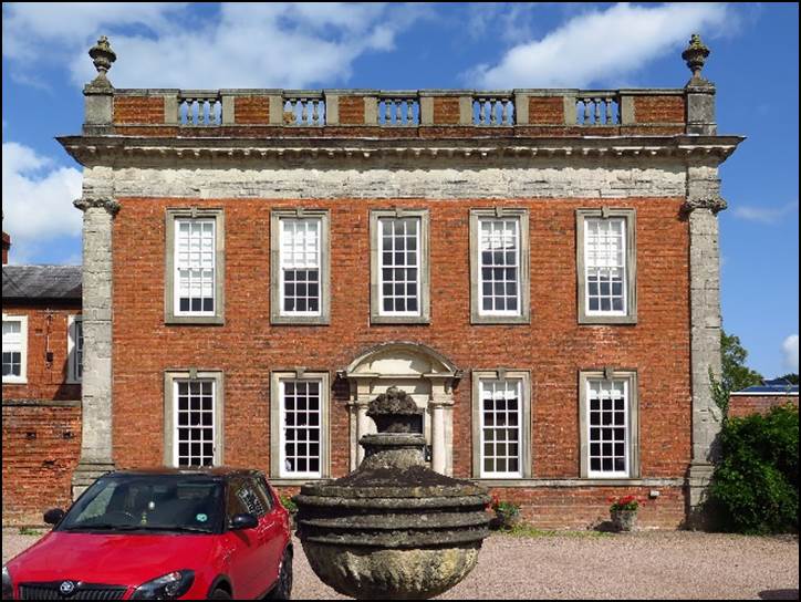 A red car parked in front of a building with a fountain

Description automatically generated with low confidence