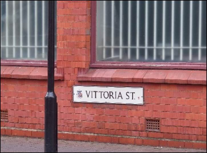 A fire hydrant in front of a brick building

Description automatically generated