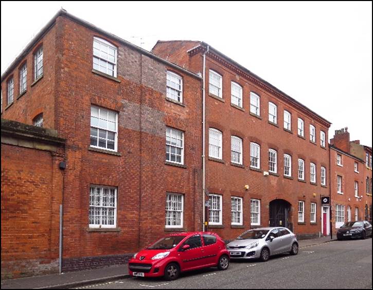 A car parked in front of a brick building

Description automatically generated