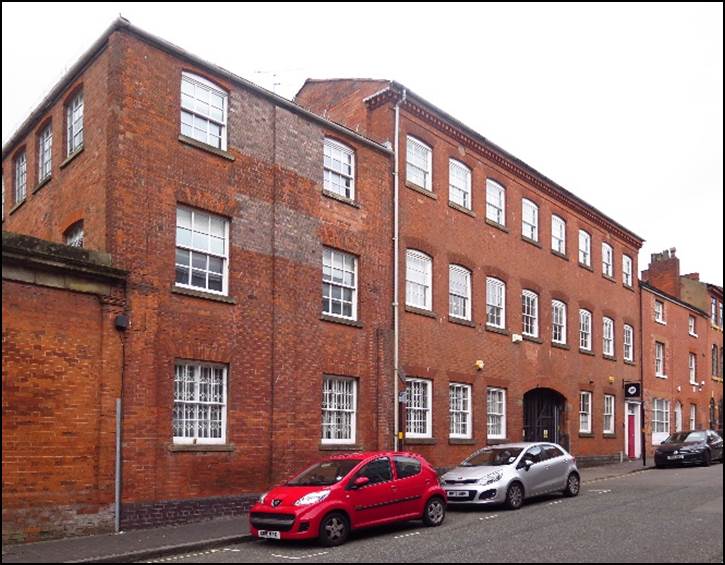 A car parked in front of a brick building

Description automatically generated