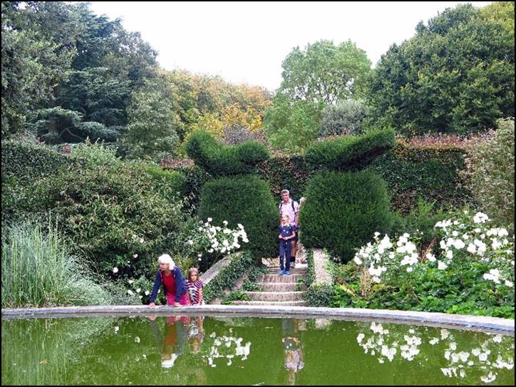 A group of people walking on a bridge over a pond

Description automatically generated with low confidence