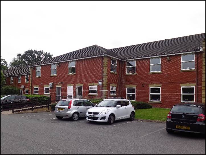 A row of cars parked in front of a brick building

Description automatically generated with medium confidence