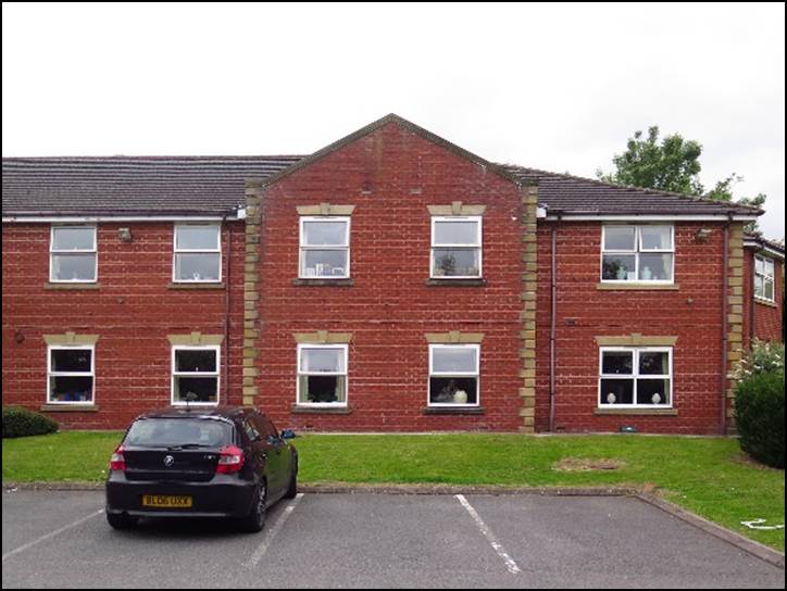 A car parked in front of a brick building

Description automatically generated with medium confidence