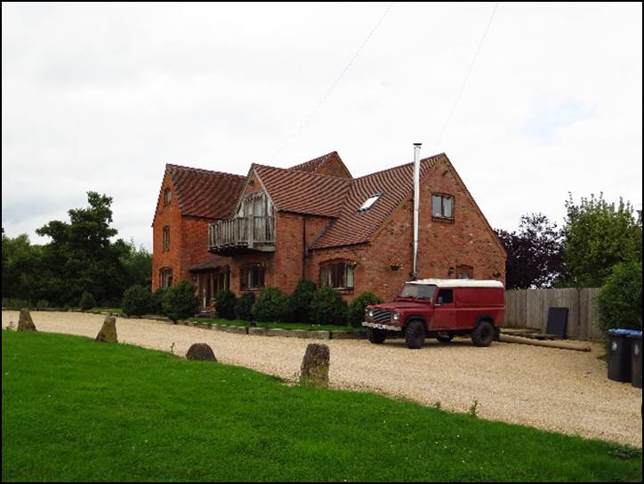 A red house with a white truck parked in front of it

Description automatically generated with low confidence