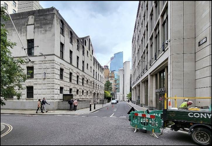 A street with buildings and people walking on it

Description automatically generated