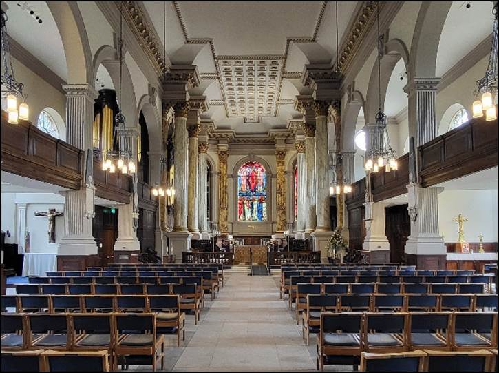 A large church with rows of pews and a stained glass window

Description automatically generated with low confidence