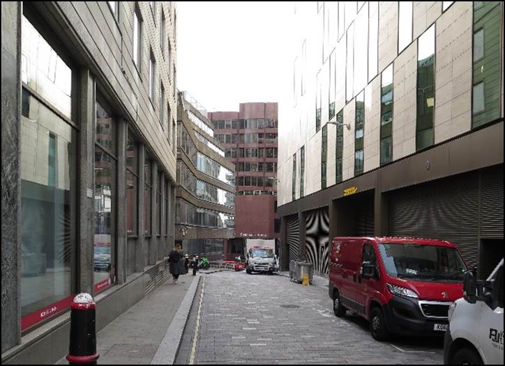 A street with cars parked in front of buildings

Description automatically generated