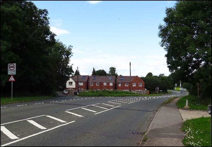 A road with a building in the background

Description automatically generated with low confidence