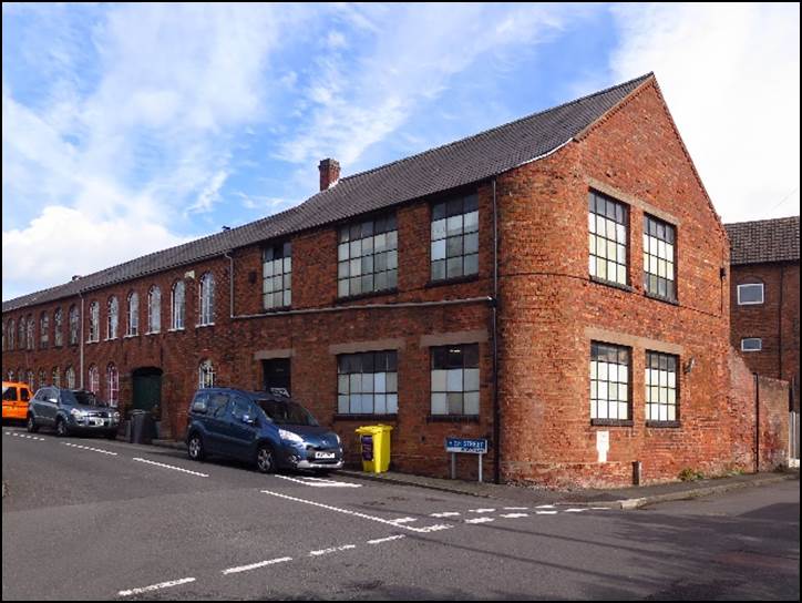 A brick building with cars parked in front of it

Description automatically generated with medium confidence