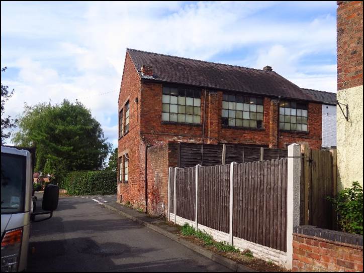 A brick building with a fence around it

Description automatically generated with low confidence