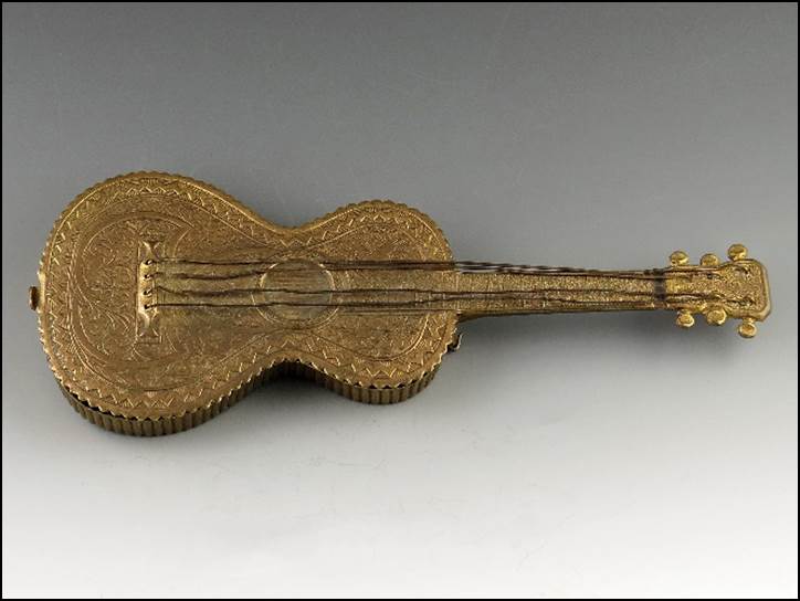 A gold guitar shaped object

Description automatically generated