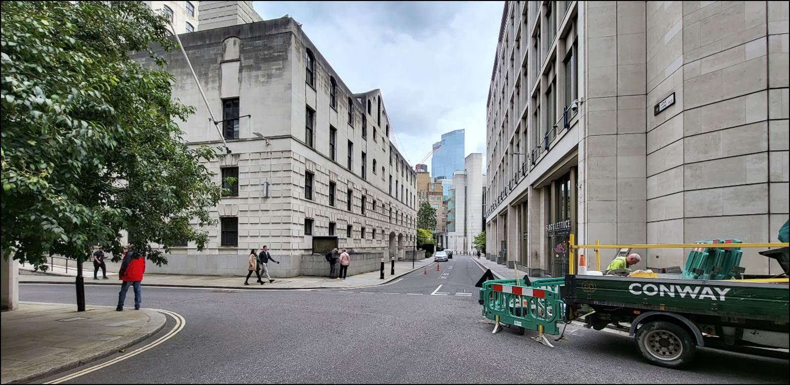 A street with buildings and people walking on the street

Description automatically generated