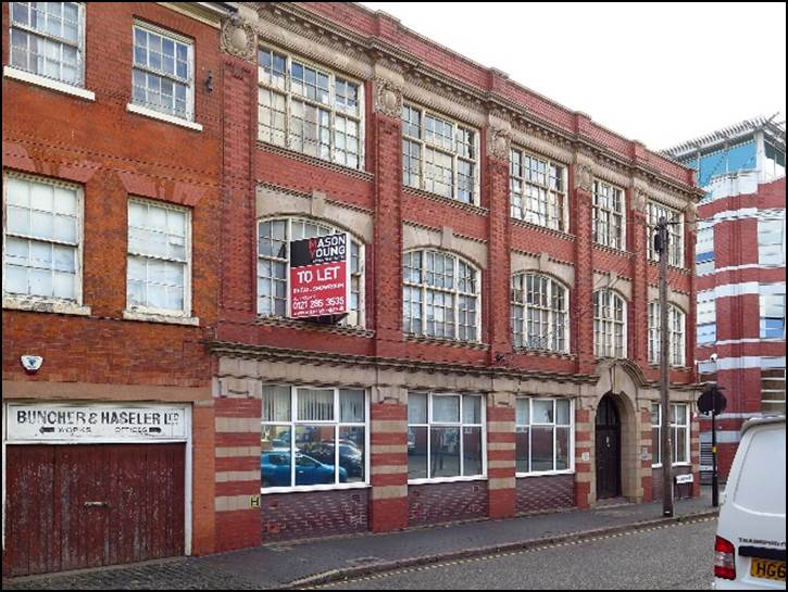 A car parked in front of a brick building

Description automatically generated