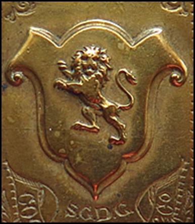 A gold rectangular object with a lion on it

Description automatically generated