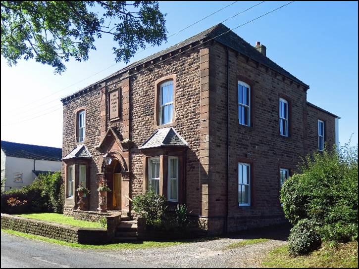 A brick house with a driveway

Description automatically generated