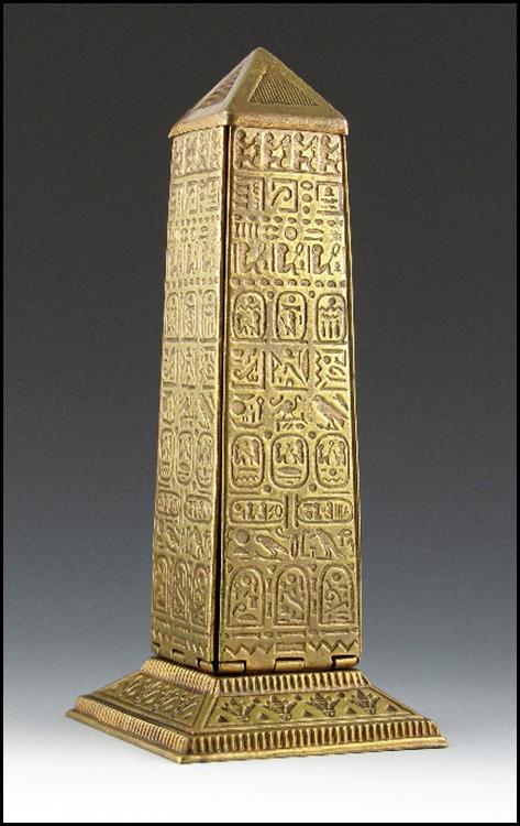A gold obelisk with writing on it

Description automatically generated