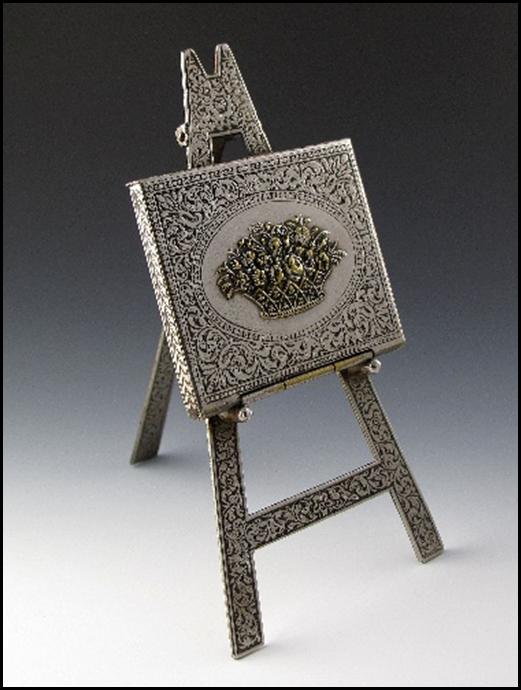 A small metal easel with a square picture

Description automatically generated