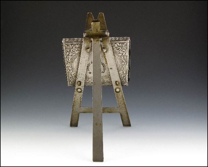 A small metal easel with a small square object

Description automatically generated