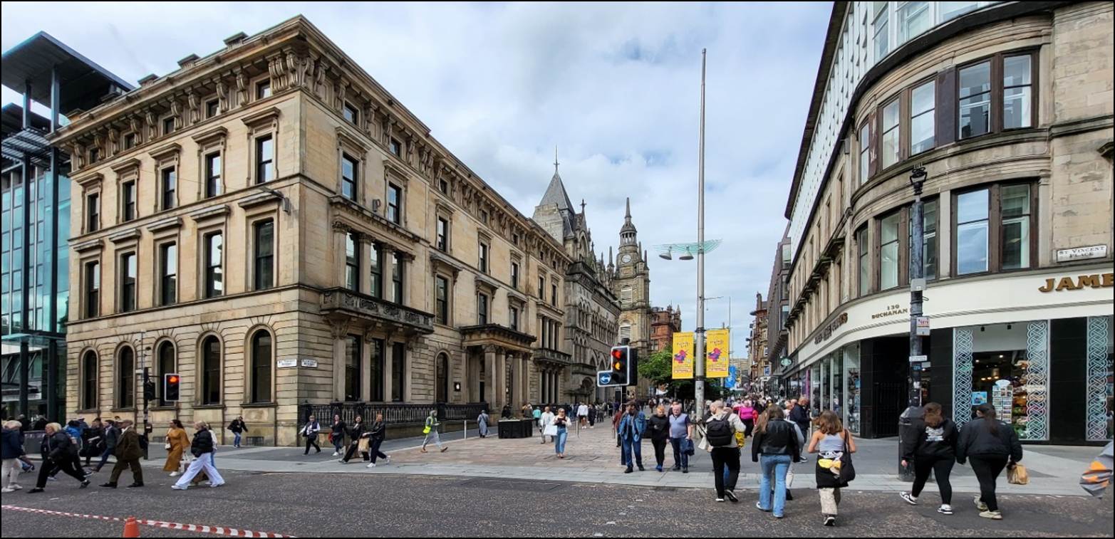 A group of people walking in a city street

Description automatically generated