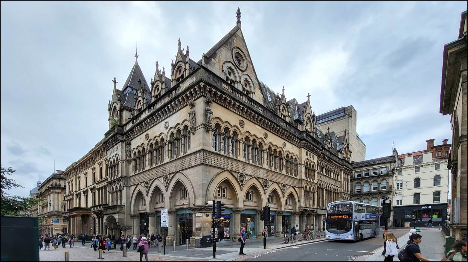 A large building with a bus on the street

Description automatically generated