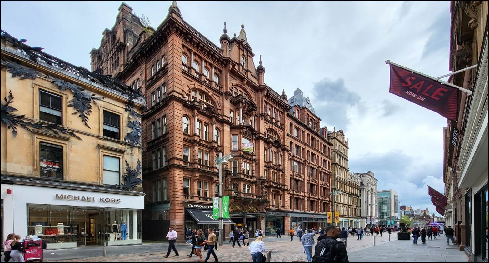 A group of people walking in a city

Description automatically generated