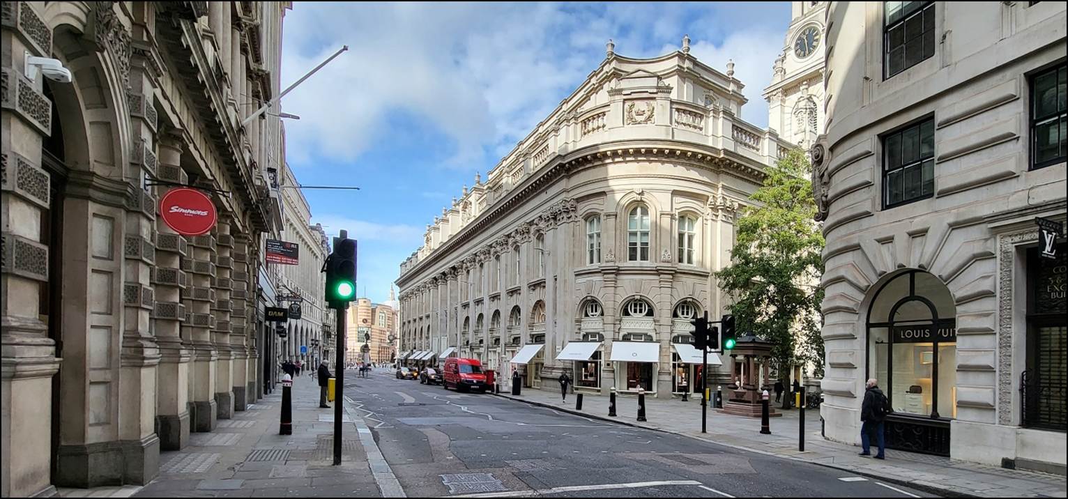 A street with a building and traffic lights

Description automatically generated