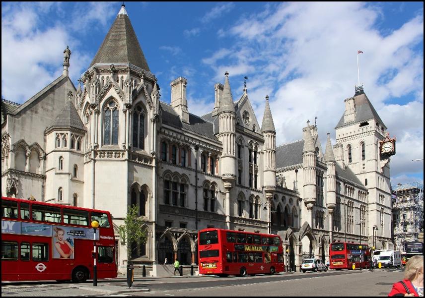 A double decker buses parked in front of a large building

Description automatically generated