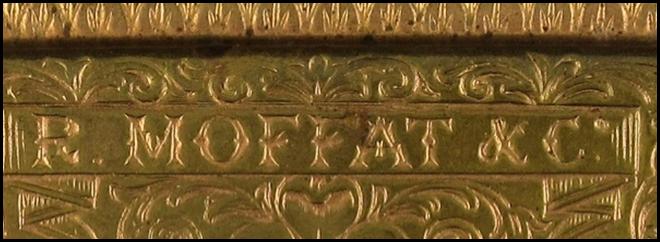 A gold square object with a symbol on it

Description automatically generated