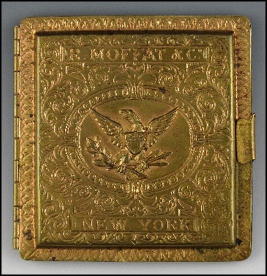 A gold square object with a symbol on it

Description automatically generated