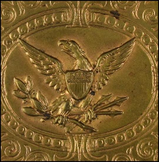 A gold square object with a symbol on it

Description automatically generated