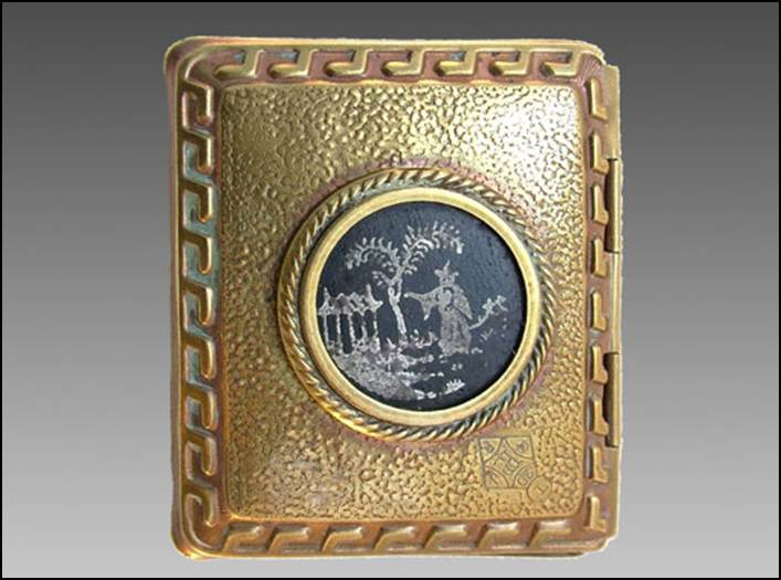 A gold colored rectangular object with a picture on it

Description automatically generated