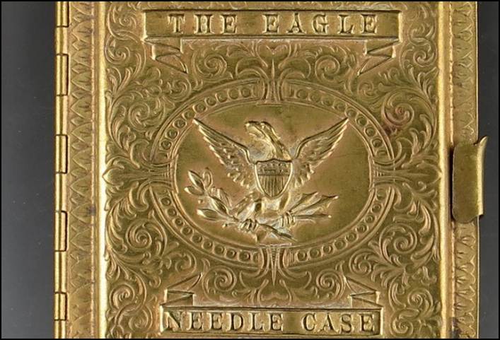 A gold metal case with a eagle on it

Description automatically generated