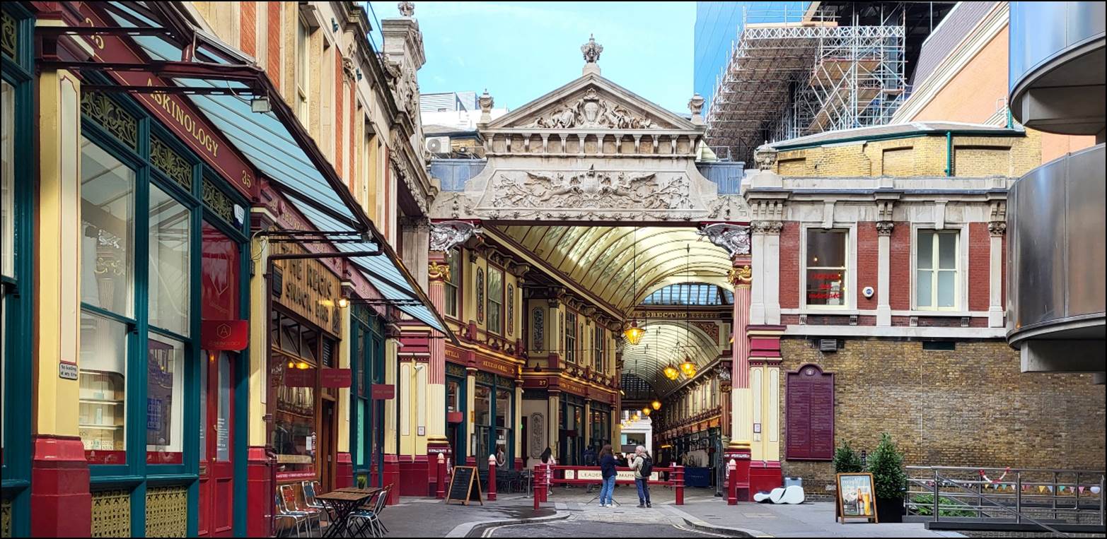 A street with buildings and people with Leadenhall Market in the background

Description automatically generated