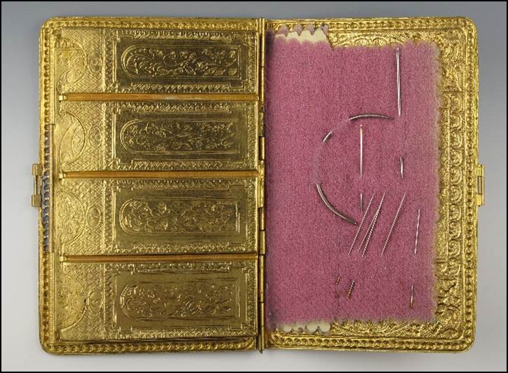 A gold case with needlework

Description automatically generated with medium confidence