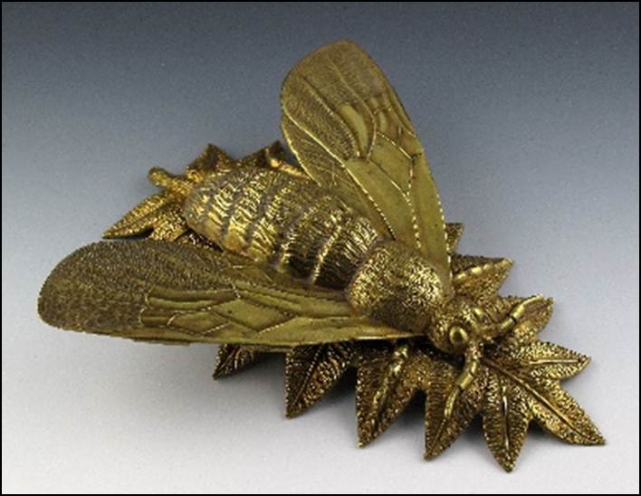 A gold insect on a leaf

Description automatically generated