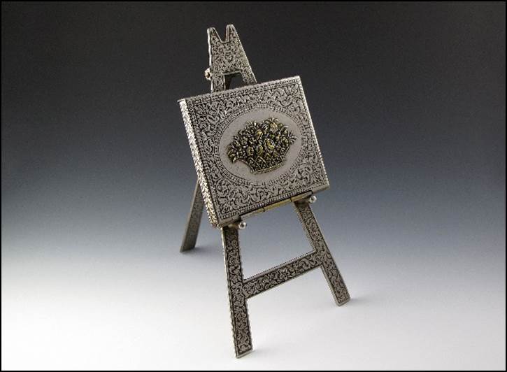 A small metal easel with a square picture

Description automatically generated